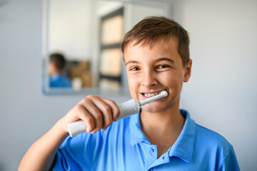 child brushes his teeth and smiles on a blue background