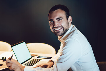 Cheerful Caucasian proud ceo formally dressed feeling excited at office interior satisfied with finished startup project, happy businessman smiling at camera during working process in big enterprise