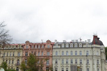 In the foreground, there is a picturesque row of buildings, all lined up neatly, while a cloudy sky looms majestically in the background