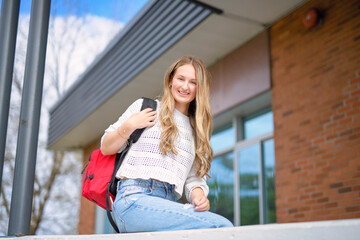 Obraz premium Young girl high school or college student She is on her way to class near university building