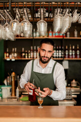 Skilled bartender prepares a cocktail at a stylish bar during a vibrant evening in a bustling city