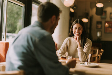 A joyful conversation over coffee and dessert in a cozy café during a sunny afternoon