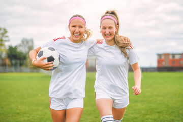 two soccer player friends with a football in a sport uniform wearing in white