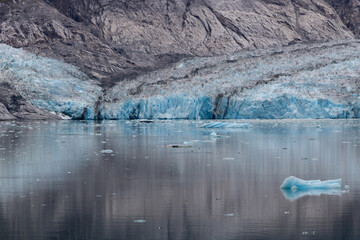 Glacier blue ice view nested in a rocky landscape by the water
