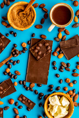 Chocolate bars and nuts on blue table background top view