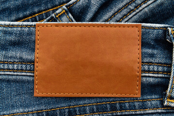 Empty worn leather patch on blue jeans. Empty space for writing. Blank leather jeans label