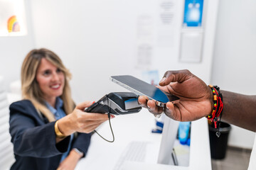 African patient paying for dental consultation using mobile payment at the clinic.