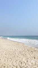 Sunny beach with gentle waves and clear blue sky, perfect for summer vacations and relaxation, evokes tranquility and escape