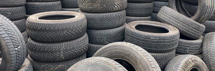 Stacks of used car tires highlight recycling and waste management challenges in automotive...