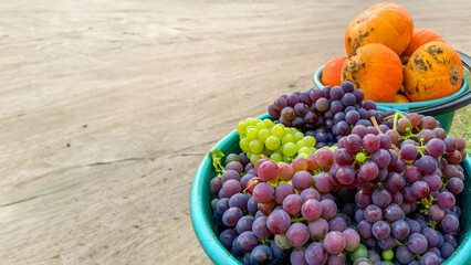 Vibrant mix of grapes and pumpkins in baskets symbolize harvest season and Thanksgiving celebrations, emphasizing abundance and gratitude