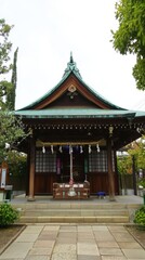 Obraz premium A serene traditional shrine surrounded by lush greenery in a peaceful urban setting