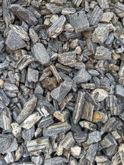 Background of natural gray small pebbles or stone in a garden paths and flower beds.