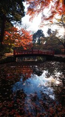 Fototapeta premium Autumn serenity at a tranquil Japanese garden bridge reflecting vibrant foliage during sunset