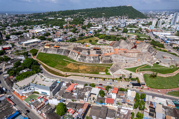 Fototapeta premium Beautiful aerial drone view of the San Felipe Castle, with the huge Cartagena Flag waving and the city in the the background