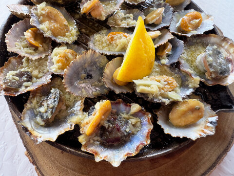 Close-up of Lapas grelhadas in their shells with garlic, lemon and  butter