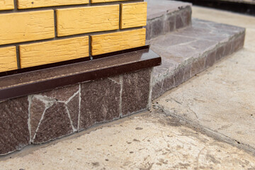 The basement of the house is lined with stone. Facing the porch with stone