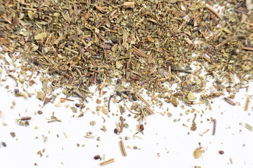 Dry basil spice seasoning macro texture on white background.