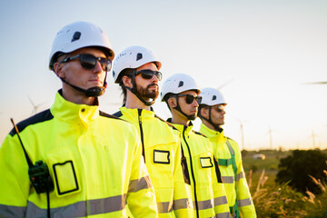 Engineers in fully safety suit and headwear are posing to camera.