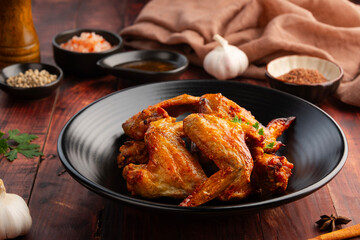 Air Fryer Chicken whole wings (Chicken 3 Joint Wing) with salt in black plate.Crispy and Healthy cooking.