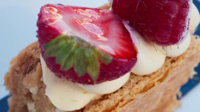 Close up of a pice of cake with cream and berries on top