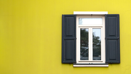Open wooden shutters on yellow wall. Rustic background idea concept. Wooden window village cottage house.