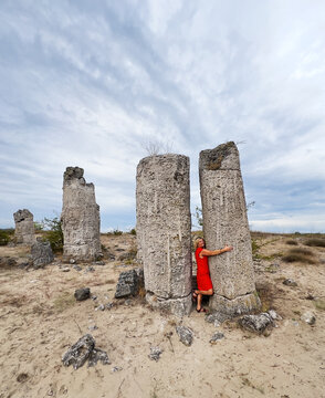 Woman hugging a stone in a stone forest (Pobiti kamni), Varna Province, Bulgaria