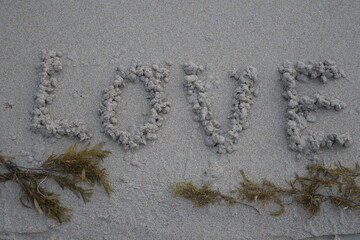 letters and writings of love in the sand on the beach. heart writings on the sand for loved ones. Happy Couples in the world. love writings in the plague of clear skies and clean air