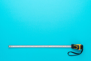 Flat lay image of construction measuring tape. Top view minimalist photo of tape measure on...