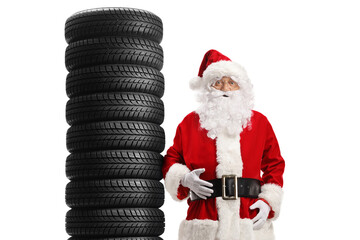 Santa claus leaning on a pile of car tires