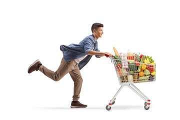 Teenager running with a shopping cart full of groceries © Ljupco Smokovski