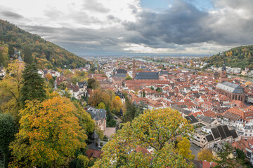 Fototapeta premium View from Heidelberg castle towards the town Heidelberg during autumn. Wonderful landscape with hills, forests and city centre. 31 october 2023, Heidelberg, Germany