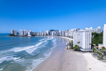 Aerial view of Praia da Pitangueiras beach in Guaruja, Sao Paulo showcasing glistening waters and high-rise buildings on a sunny day