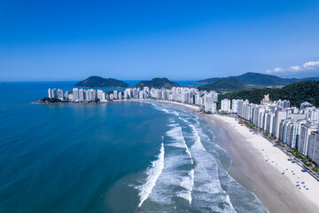 Aerial view of Praia da Pitangueiras beach in Guaruja, Sao Paulo showcasing glistening waters and high-rise buildings on a sunny day