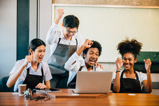 Team meeting in stylish coffee shop with diverse entrepreneurs. Barista owner discuss work on laptop. Multiethnic employees successful teamwork business discussion.