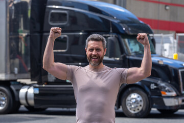 Happy Truck driver. CDL. Portrait of trucker standing by his truck vehicle ready for transport....