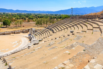Stone amphitheater with a grassy hill in the background, amphitheater. Ruins of the ancient city of Philippi, Greece
