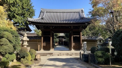 Fototapeta premium Tranquil entrance to a historic temple surrounded by lush greenery on a sunny afternoon