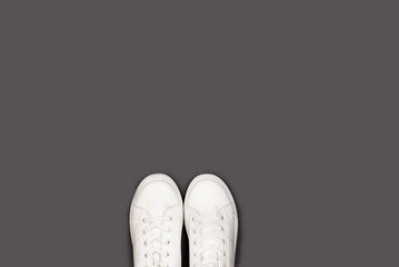 Clean white sneakers on a gray background. Perfect for fashion, footwear, and product photography.
