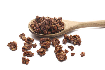 Crunchy granola, muesli pile with chocolate in wooden spoon isolated on white background, side view