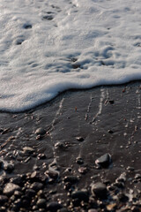 white foam waves on the each with lack sand