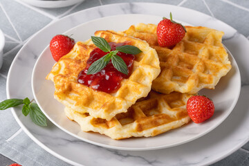 Waffles with strawberry jam and strawberries for breakfast