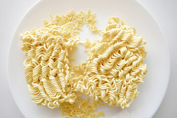 Uncooked instant noodles on a white plate. 