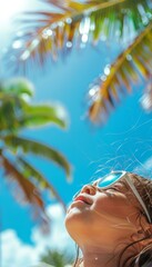 of a little girl wearing stylish sunglasses, looking up at the sky with a joyful expression while