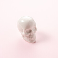 White skull on a pink background. Minimal Halloween spooky concept.