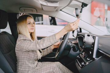 Stylish and elegant woman in a car salon