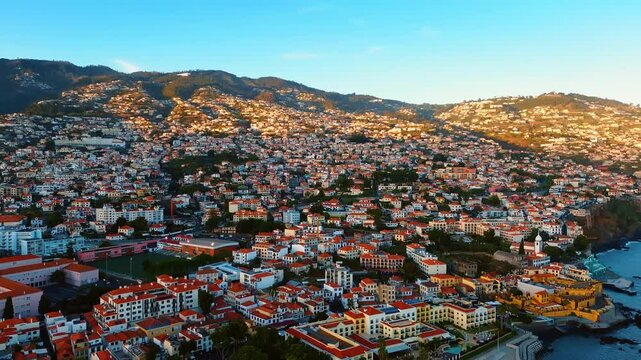 Densely built mountains slopes at the Madeira Islands, Portugal. Highly populated coast from aerial perspective. Top view.