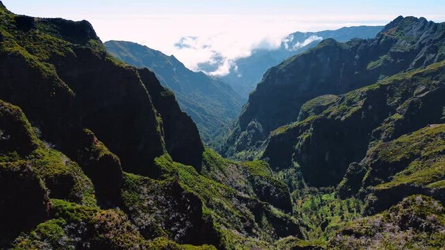Huge steep mountains covered with mosses. Rocky dangerous landscape of the Madeira Islands, Portugal. Top view.