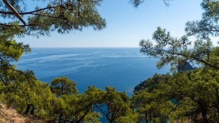 Turkish Mediterranean coastline as seen from the Lycian Way in Antalya, Turkey with a blue sea, lush green forests, and rugged rocky shores, attracting tourists every summer.