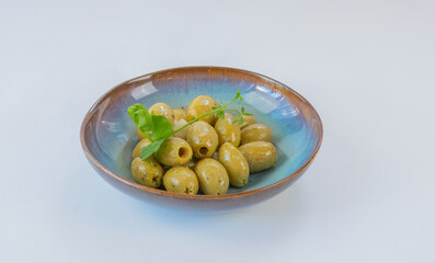Green olives in blue dish, side view