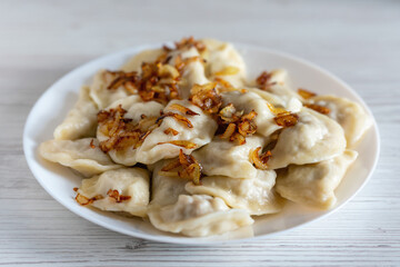 Ukrainian vareniki seasoned with fried onions in a plate on the table